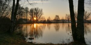 Morgendämmerung über einem stillen See