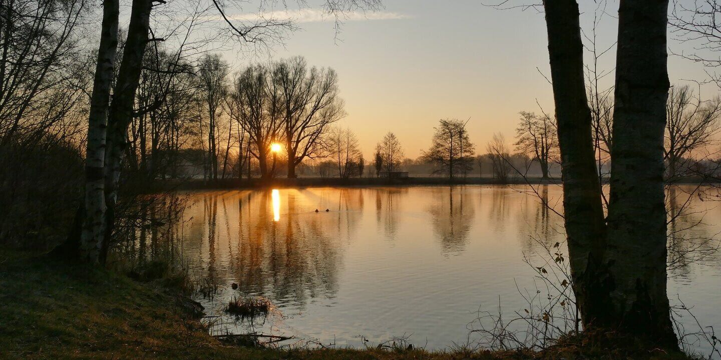 Morgendämmerung über einem stillen See